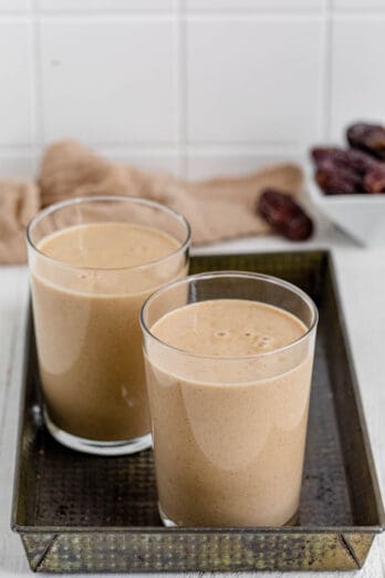 Two glasses of Banana Date Smoothie on a serving tray.