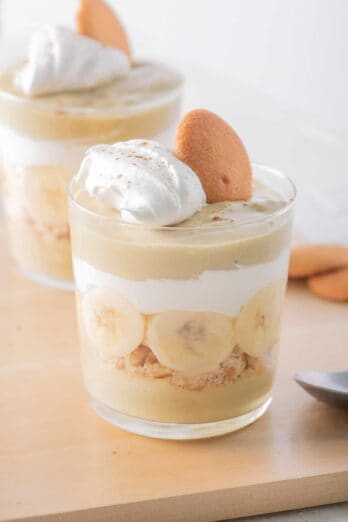 Close up of one cup of banana pudding parfait topped with a wafer