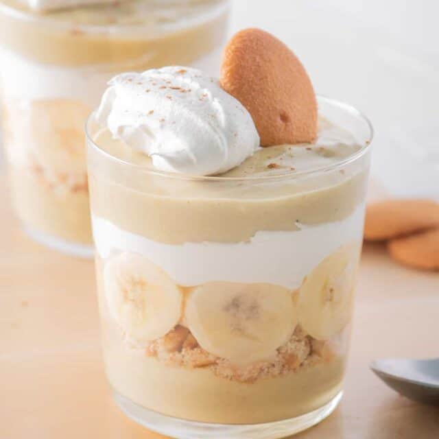 Close up of one cup of banana pudding parfait topped with a wafer