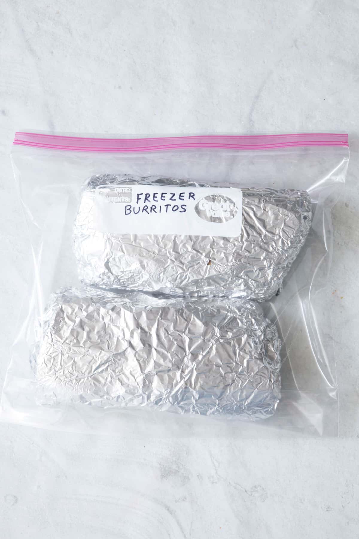 2 burritos wrapped in foil in a zip top bag.