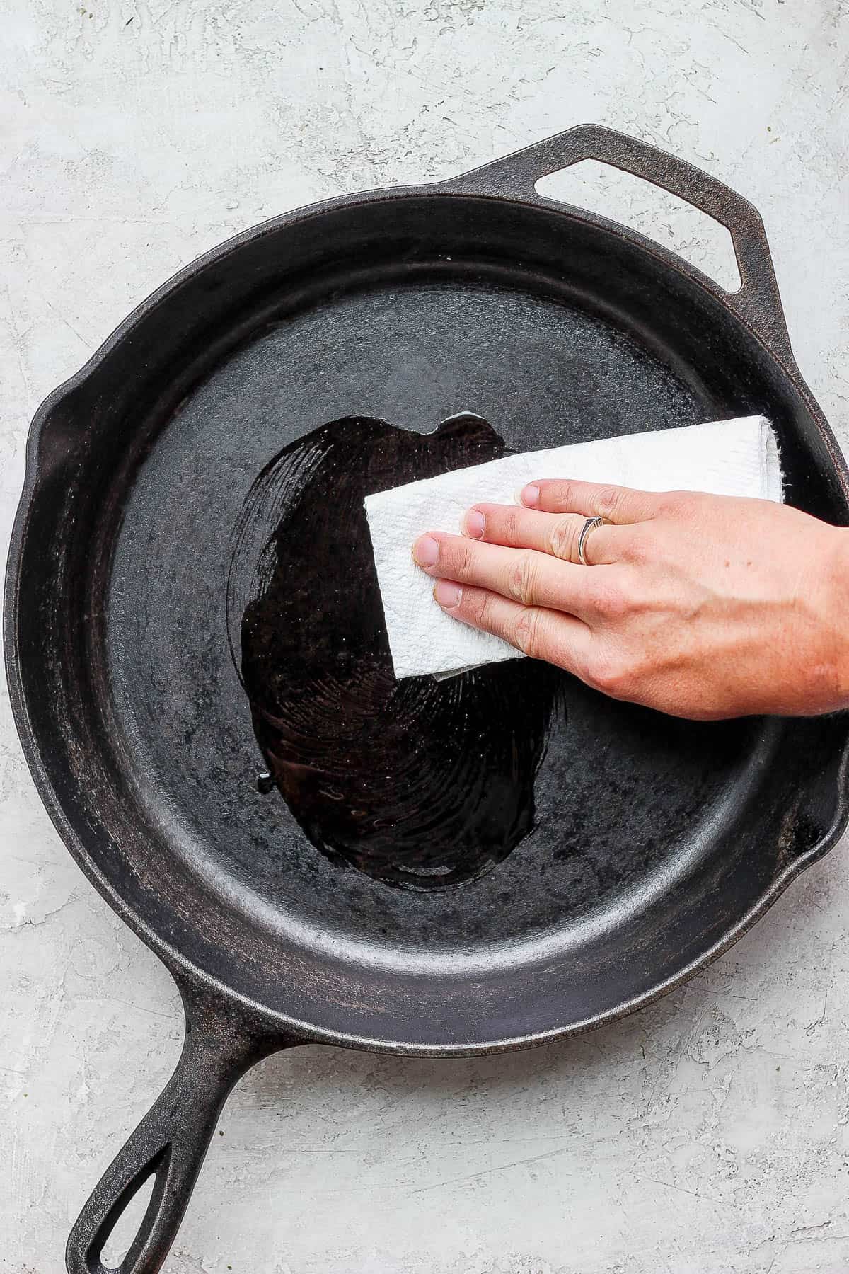 Oil being applied to a cast iron skillet.