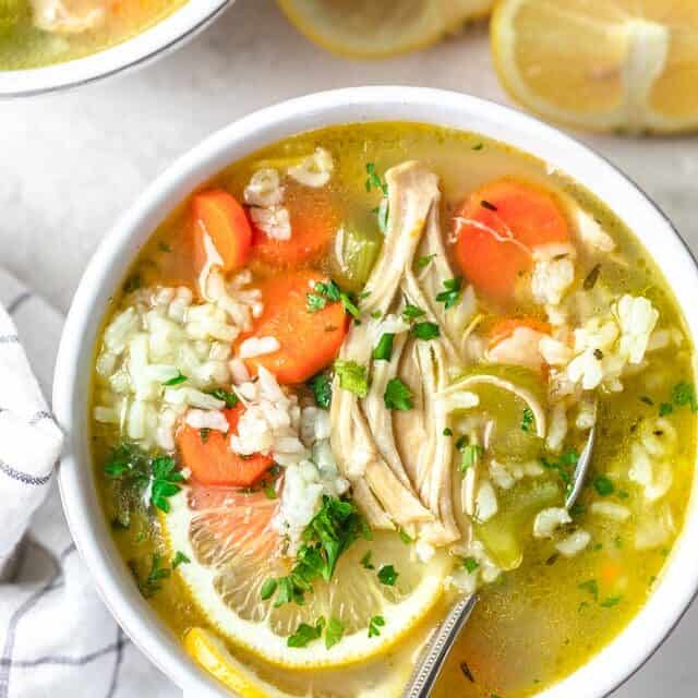 Close up shot of Chicken Lemon Rice Soup with spoon inside of large mug