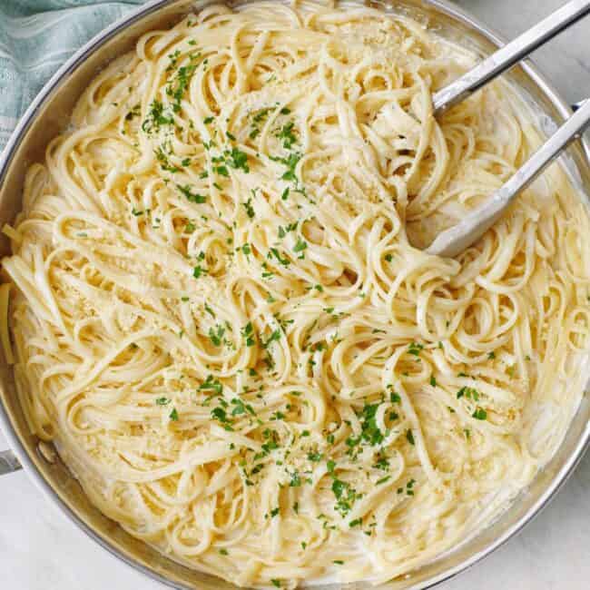 Square image of a pan of cottage cheese alfredo pasta.