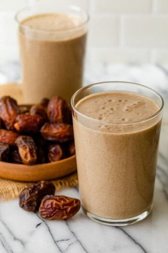 2 cups of date shakes with bowl of dates next to them