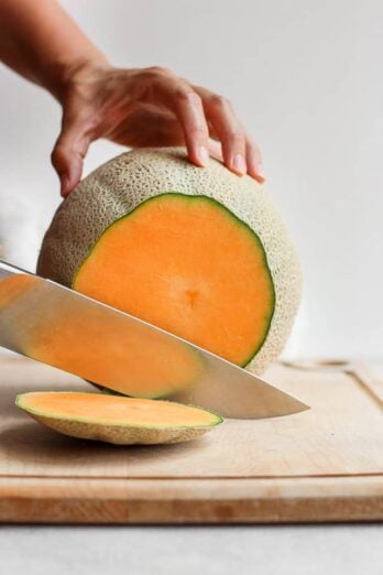 Cutting the top of cantaloupe with sharp knife