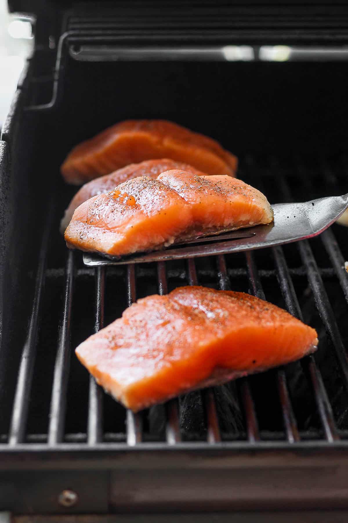 3 Salmon fillets with spatula under one before flipping it