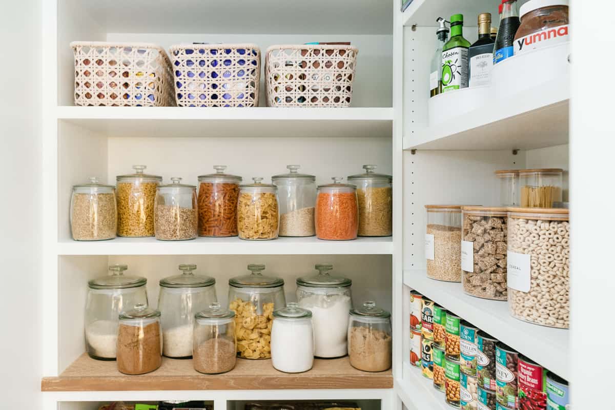 How to organize a pantry in individual glass storage containers and baskets.