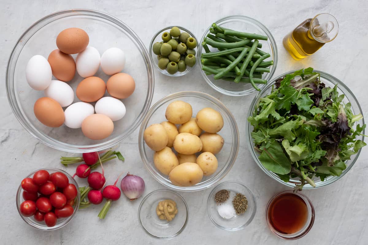 Ingredients for recipe: eggs, tomatoes, beets, olives, potatoes, green beans, shallot, mustard, seasonings, oil, spring mix, and vinegar.
