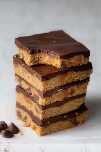 No bake cookie dough bars stacked on top of each other and top one bite taken out of it