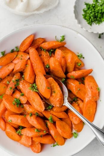 Large bowl of oven roasted carrots sprinkled with parsley