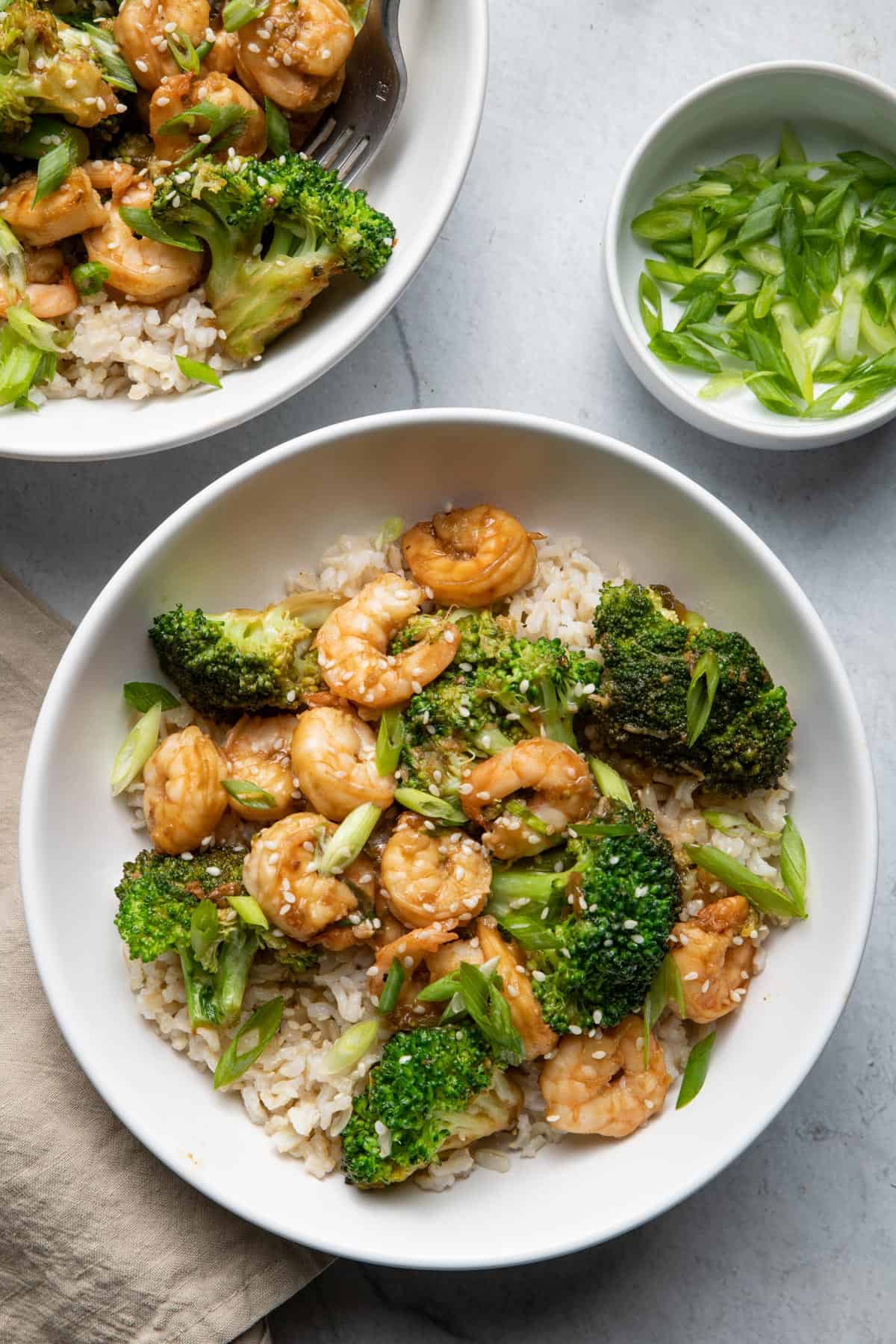 Shrimp and broccoli stir fry in bowls over brown rice