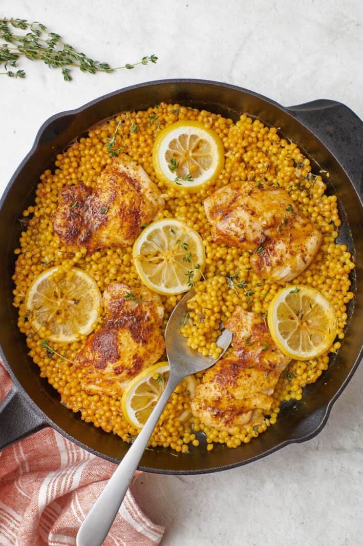 Skillet chicken with couscous in a large cast iron skillet.