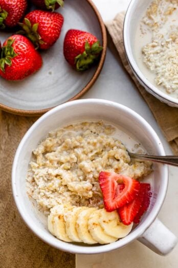 Close up shot of steel cut oatmeal topped with banana, strawberries and coconut