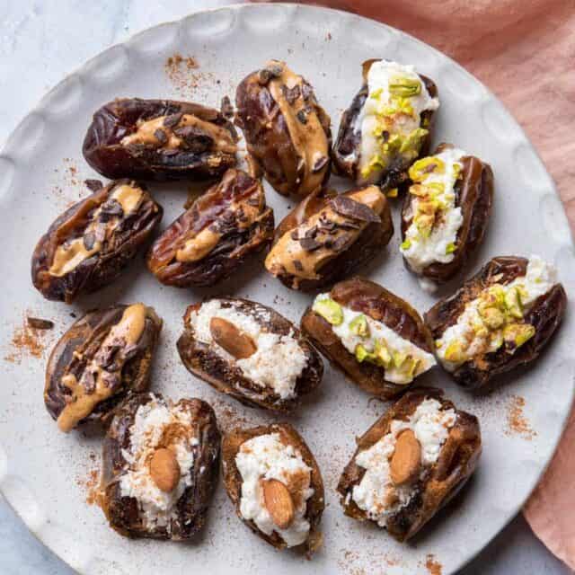 Large white plate of stuffed dates with different flavors