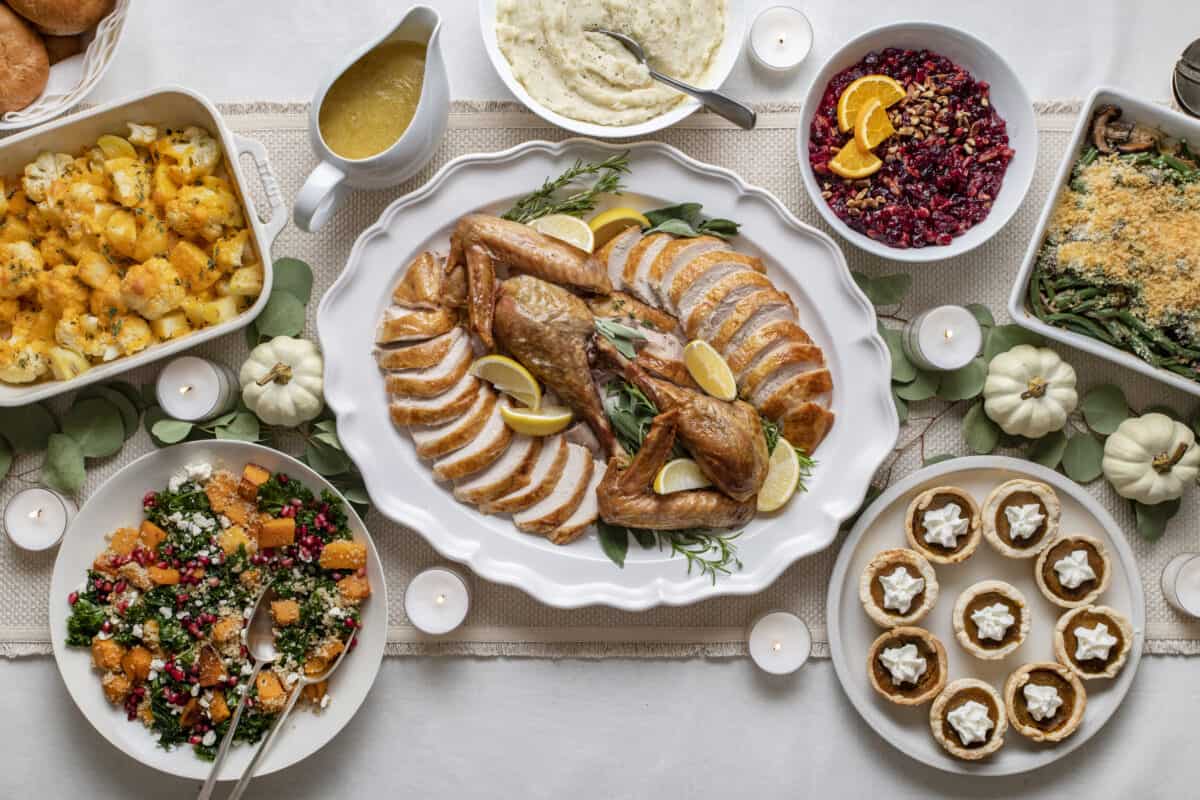 Thanksgiving dinner table 2021 with carved turkey, sides and dessert