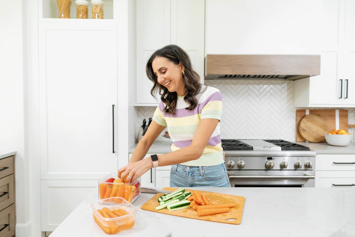 Yumna in the kitchen meal prepping cutting vegetables on counter